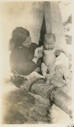 Image of Odie, 7 months, son of Etook-a-shoo, showing a can of Shefield milk. [Ole Petersen and his mother, Ane]